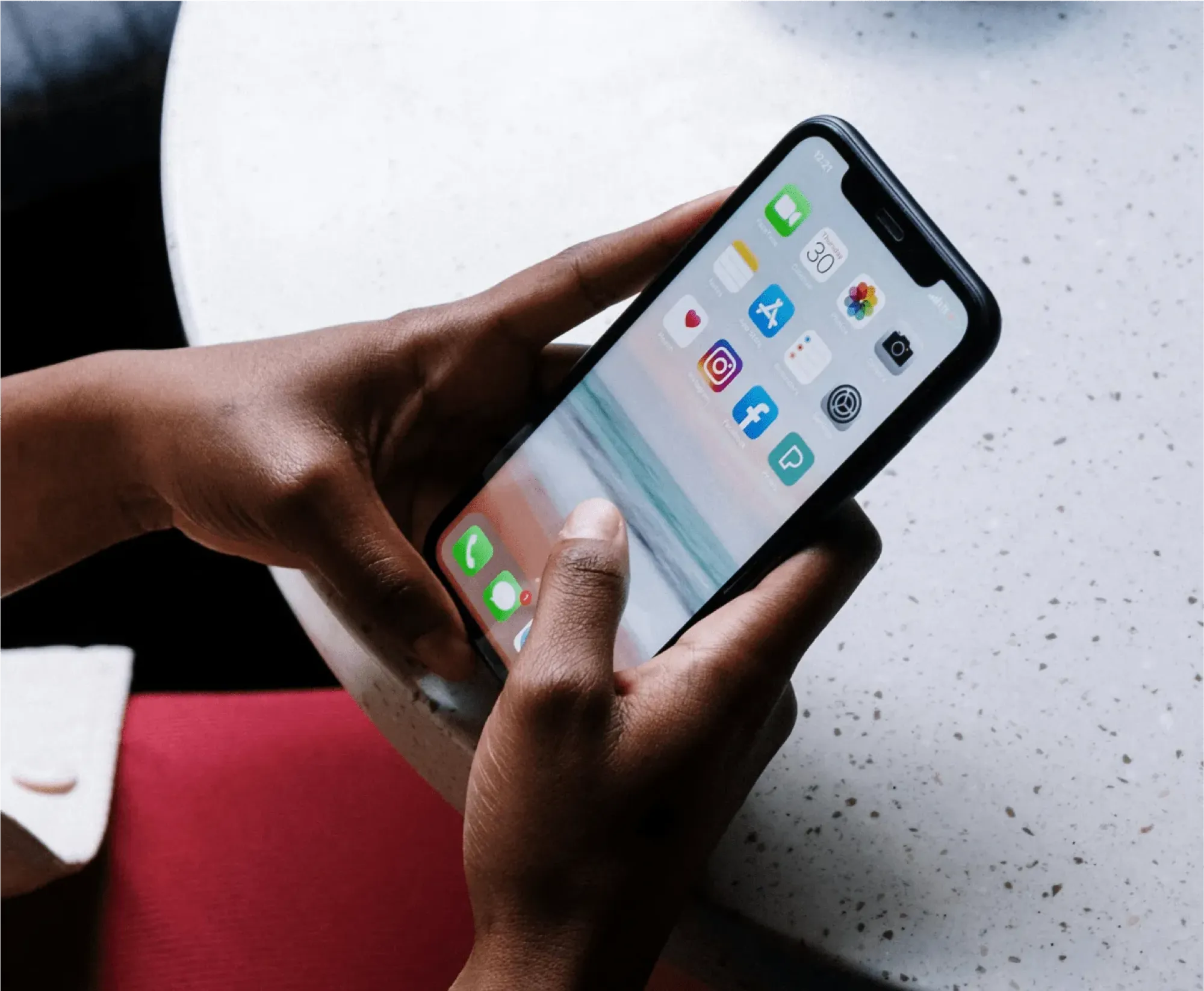A person holding an iPhone displaying various app icons, symbolizing digital estate management after a death.