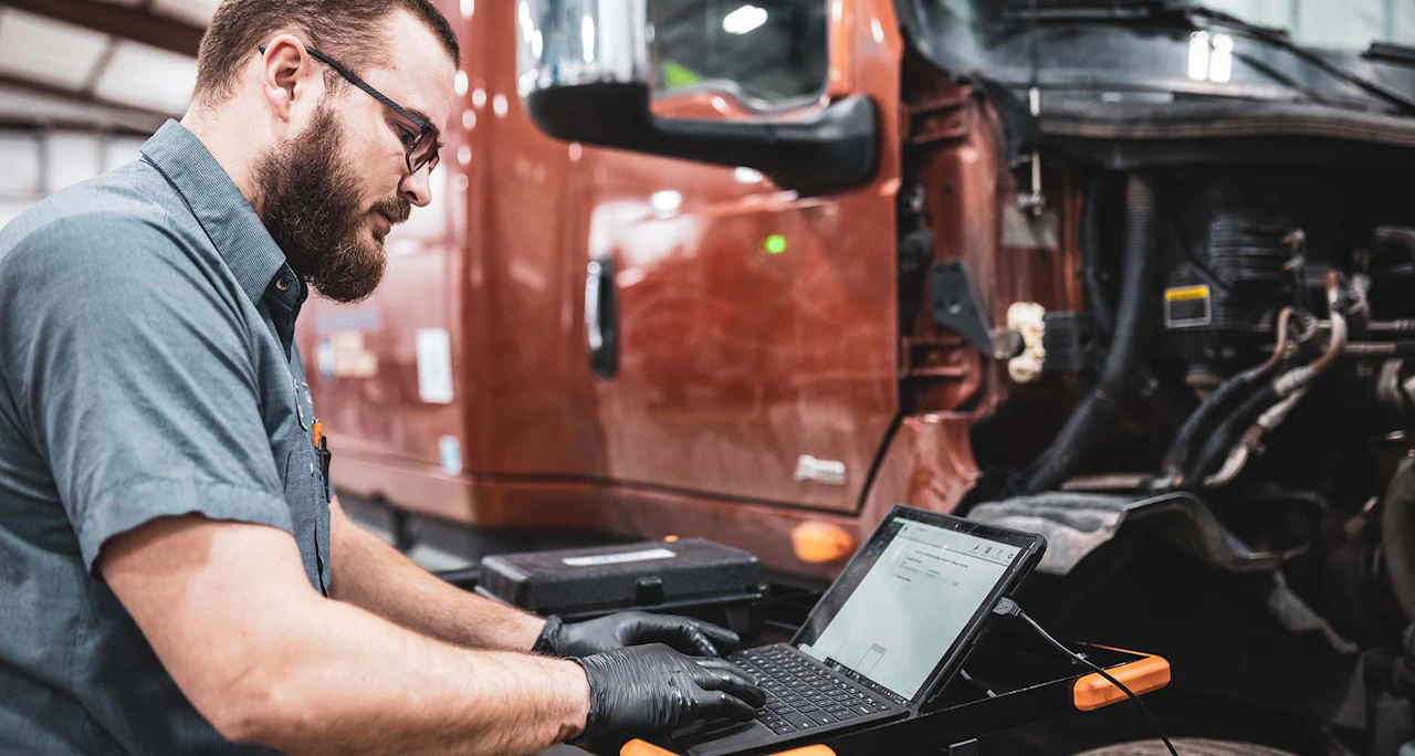 Diesel mechanic working on ECM diagnostics on a semi truck. 