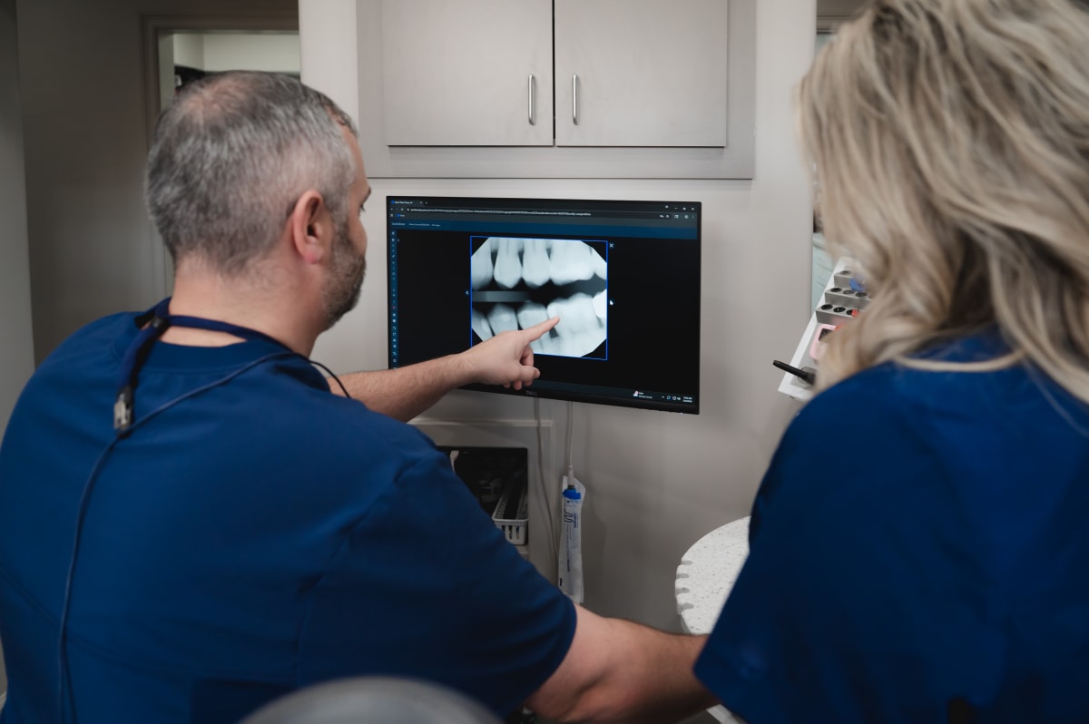 Dentist explaining root canal vs filling treatment options to patient during consultation