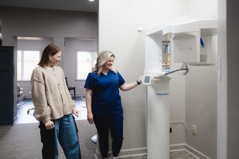 Dentist showing a patient equipment in their dental office. 