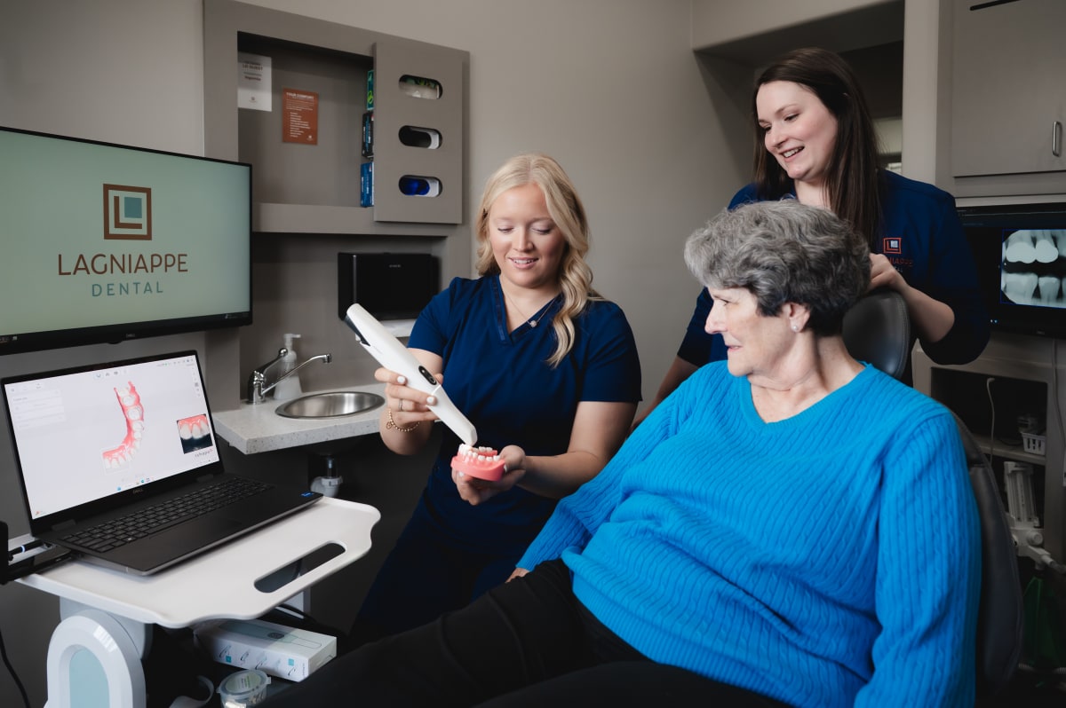 Dentists at Lagniappe Dental discussing implant treatment with a patient. 
