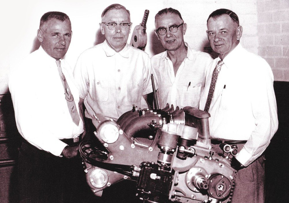Leo Goosen and colleagues gathered behind a racing engine