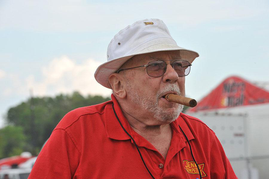 Portrait of Bill Grumpy Jenkins wearing a white hat and smoking a cigar