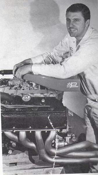 Young Maurice Petty leaning over a Petty Enterprises racing engine