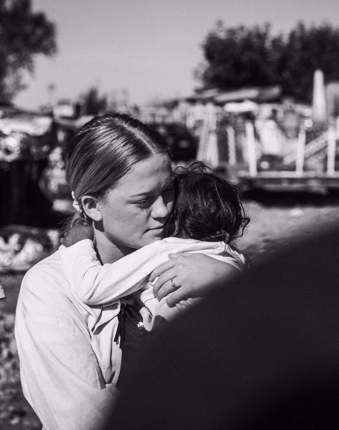 Elev omfavner et barn i slummen i Albania.