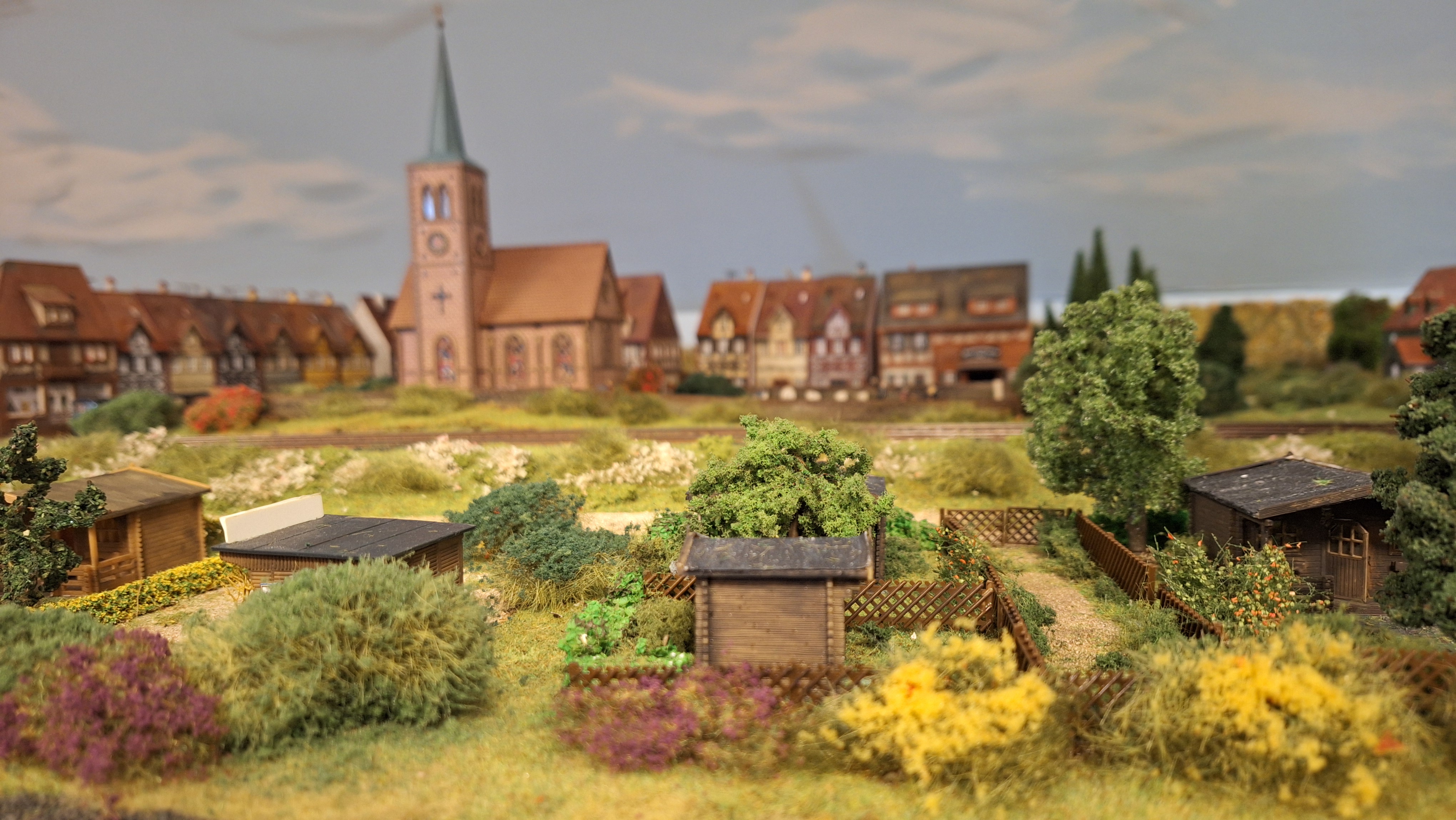 Miniatur-Güterzug mit Gleisnetz im Hintergrund