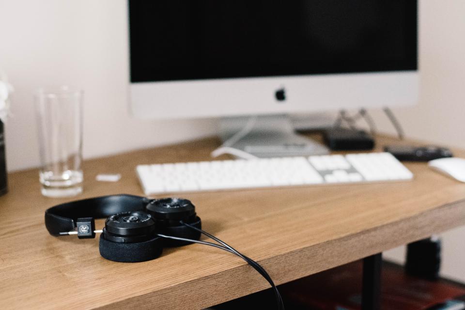 Desk with a desktop computer, keyboard and headphones