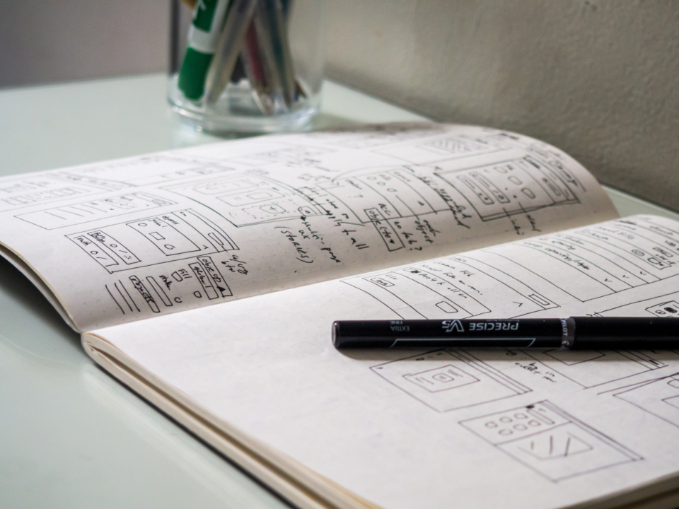 Open notebook with hand-drawn sketches and a marker