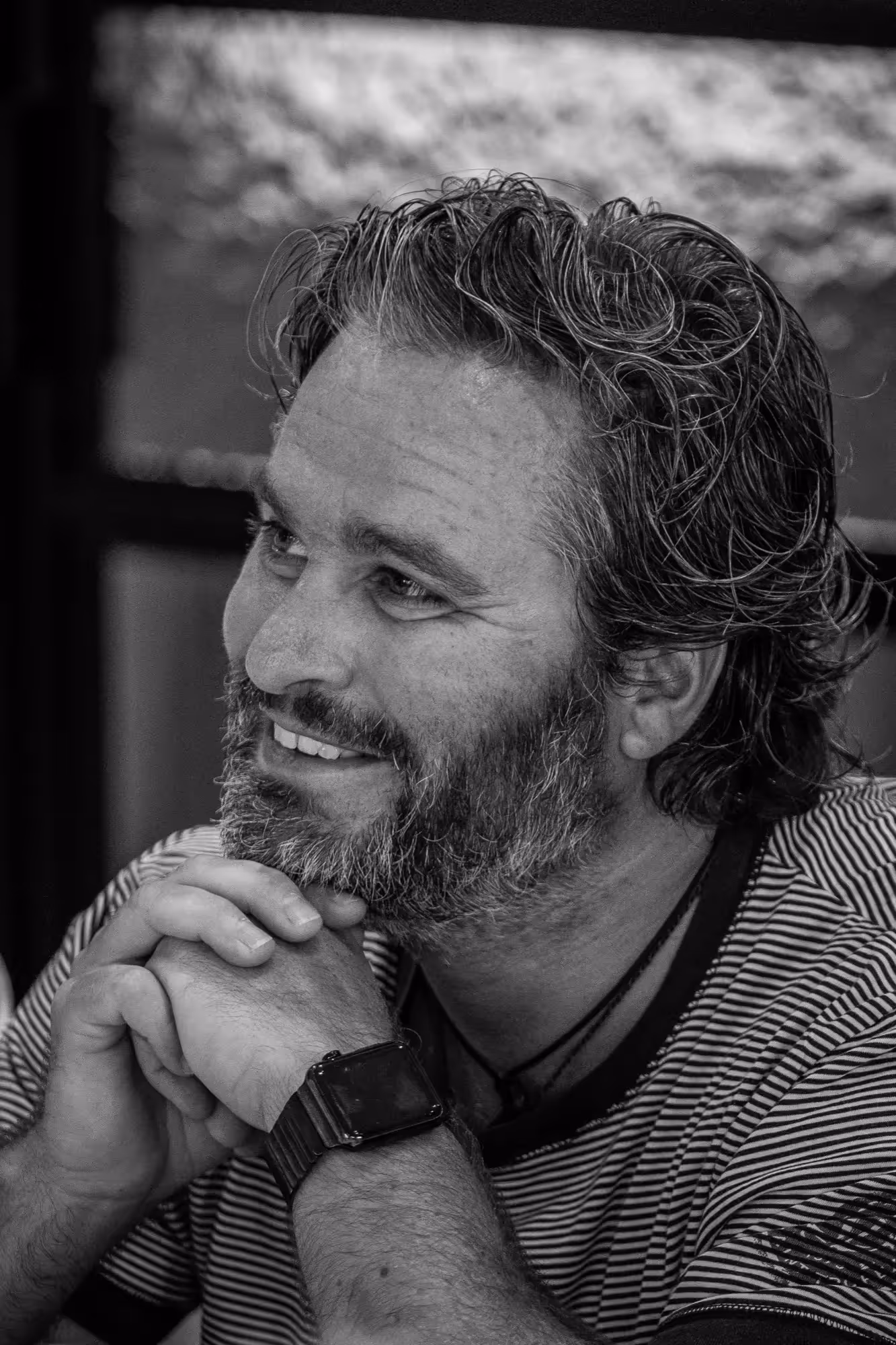 Photo de profil en noir et blanc de Flip regardant vers la droite, les mains croisées sous le menton.