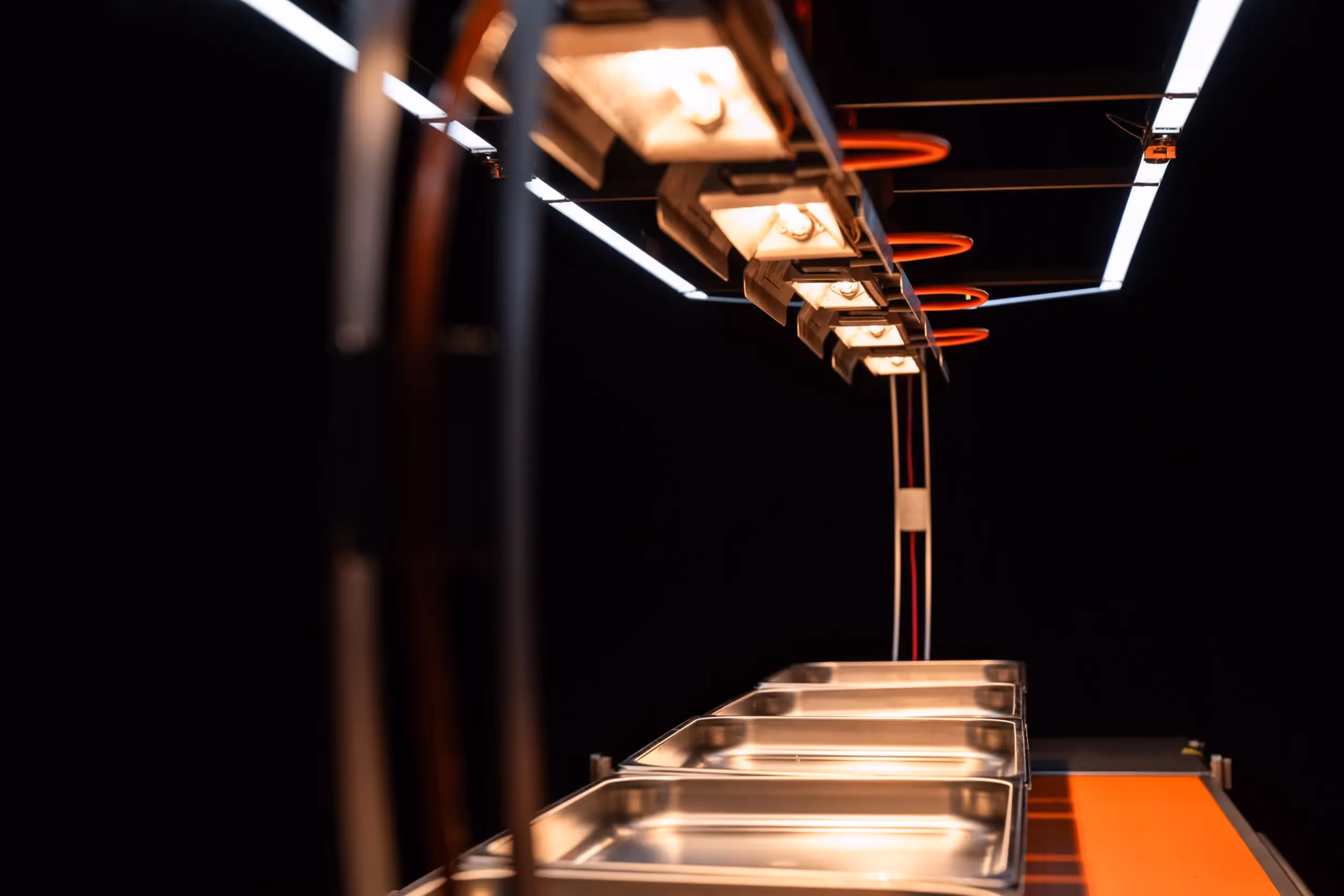 Gros plan d'un appareil Flowline avec des accents orange sous les lampes chauffantes.