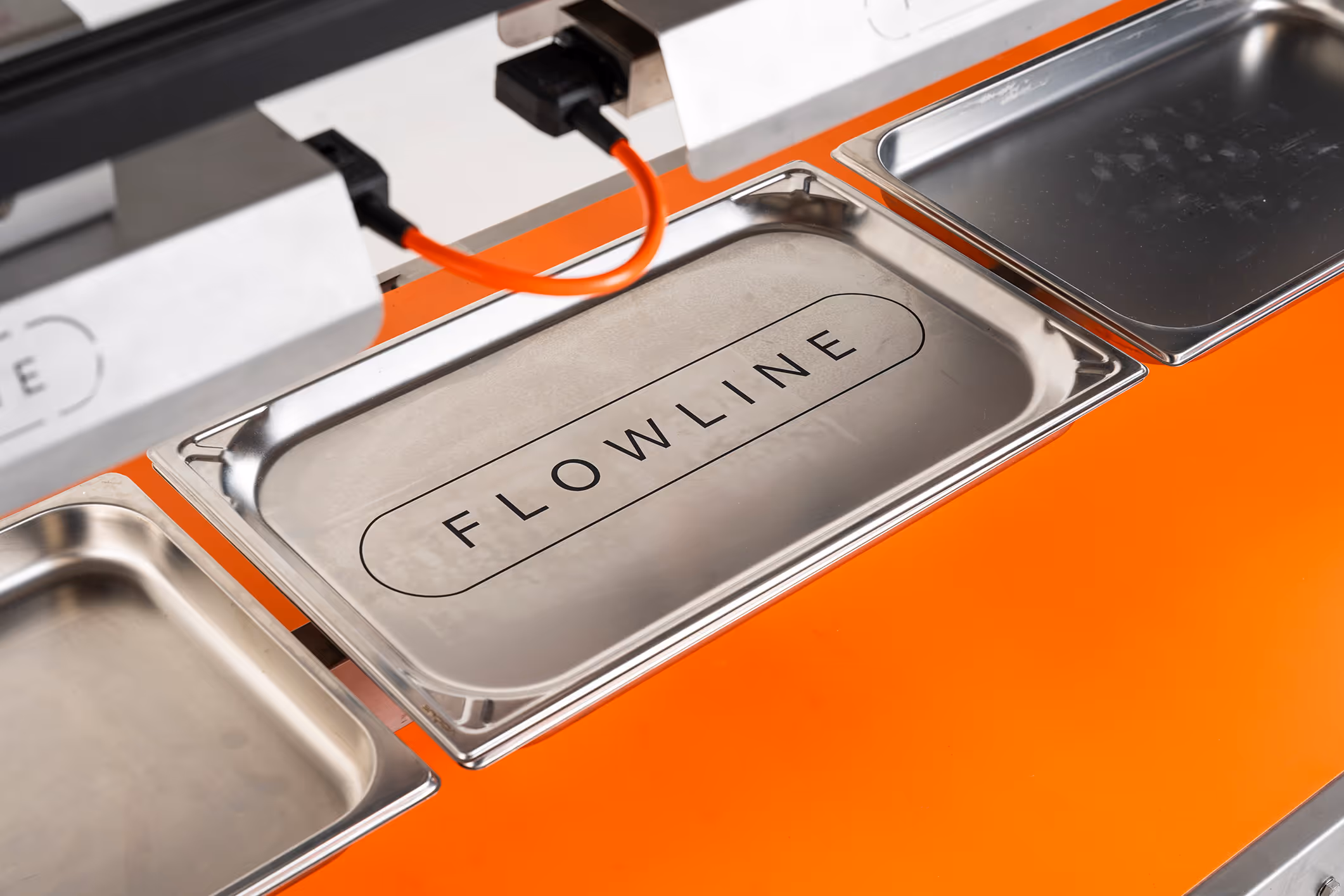 Een serie van gastronorm plateau's bevestigd op Flowline met een oranje band.