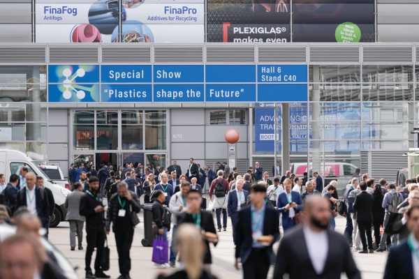 Attendees walking through the K 2025 trade fair in Düsseldorf, surrounded by innovation displays and exhibitors from the plastics and polymer industries.