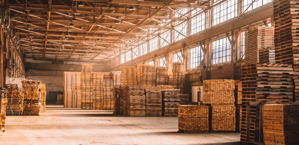 Different wooden pallet types including standard 48x40 pallet, block pallet, and heat treated pallet staged in a warehouse for LTL shipping