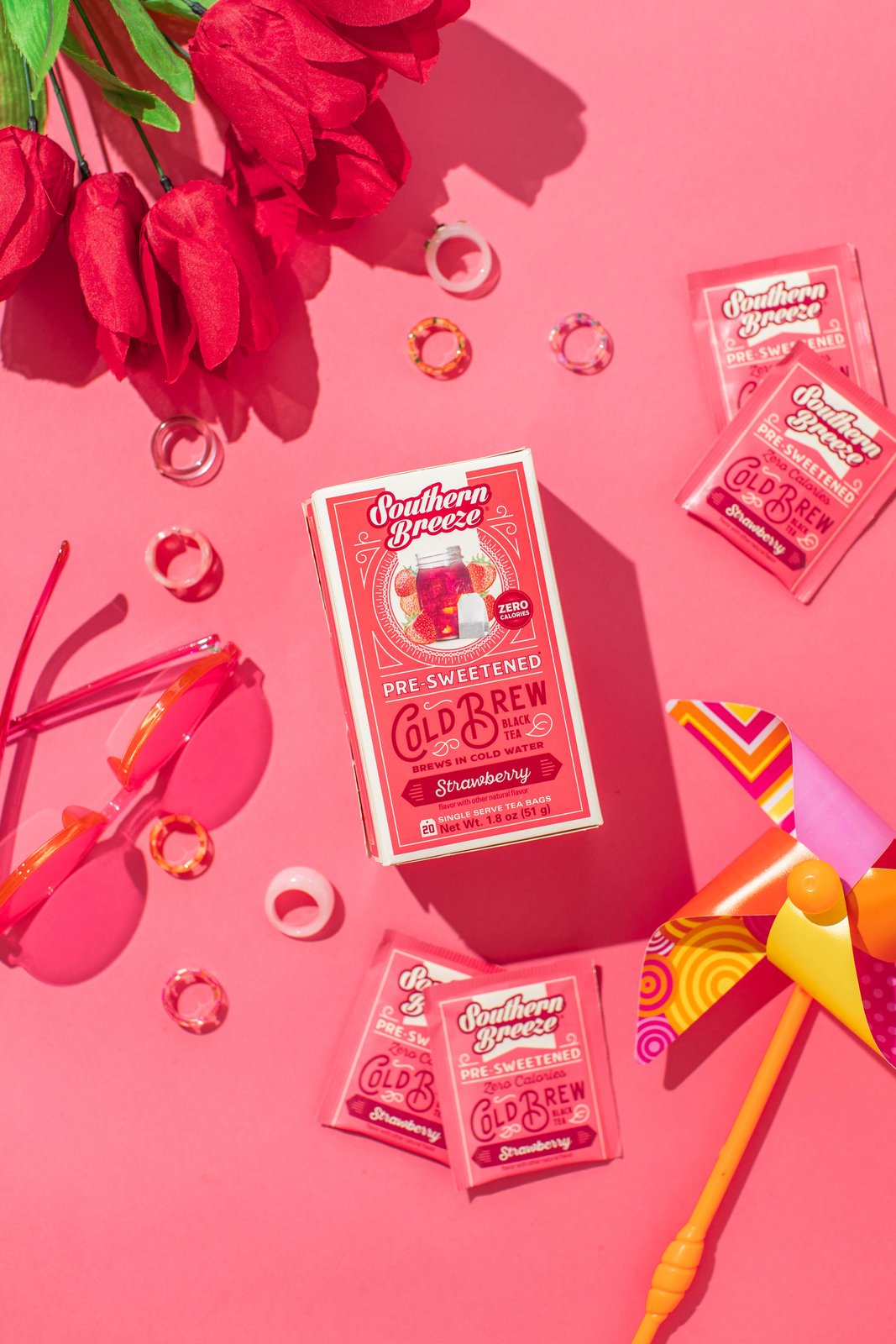 Southern Breeze raspberry cold brew tea on a pink summer flat lay