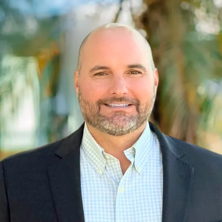 A man in a suit smiling for the camera.
