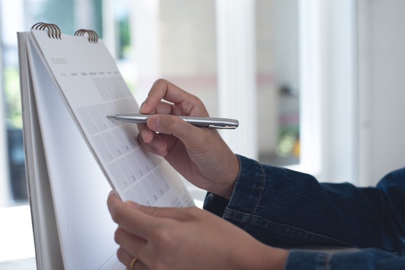 Person marking a deadline on a calendar representing the statute of limitations for filing a workers' comp retaliation claim in California