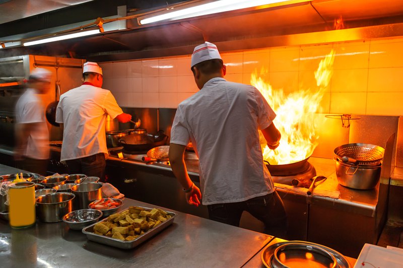 Restaurant kitchen employees working in a high-risk environment where workplace injuries and workers' compensation claims are common
