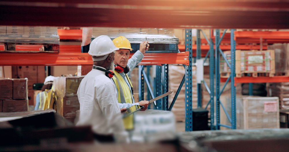 Two warehouse employees reviewing a safety concern — California law protects employees who report workplace safety violations from retaliation