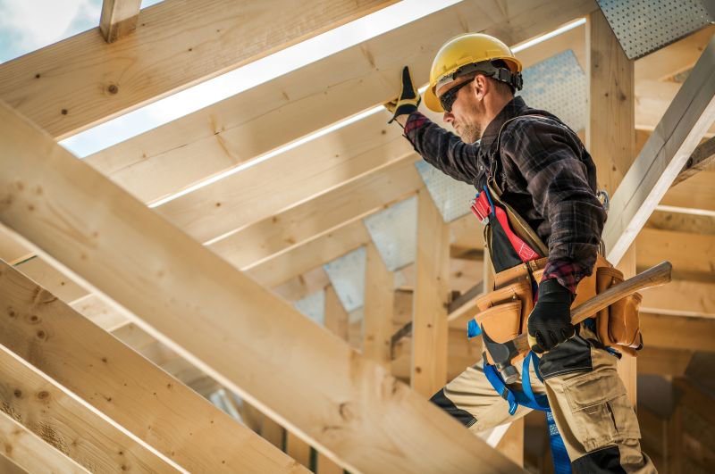 Construction worker in a yellow hard hat and safety harness on a California job site, representing skilled trade employees facing employee misclassification