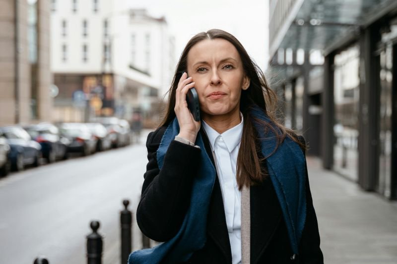 A professional woman makes a phone call while walking, taking action after experiencing maternity leave retaliation at work