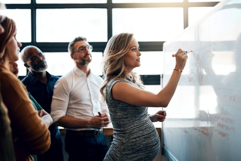 Pregnant employee leading a workplace meeting, representing California pregnancy leave rights at work