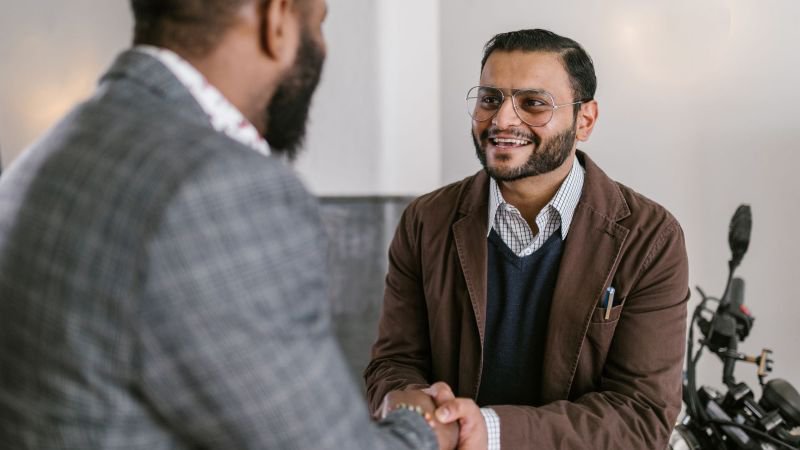 Two men shaking hands in a professional office setting, representing a California employee meeting with a family medical leave lawyer at Frontier Law Center