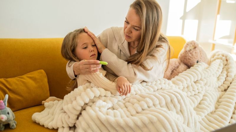 Mother checking a sick child's temperature at home, a covered use under California's paid sick leave and Kin Care law