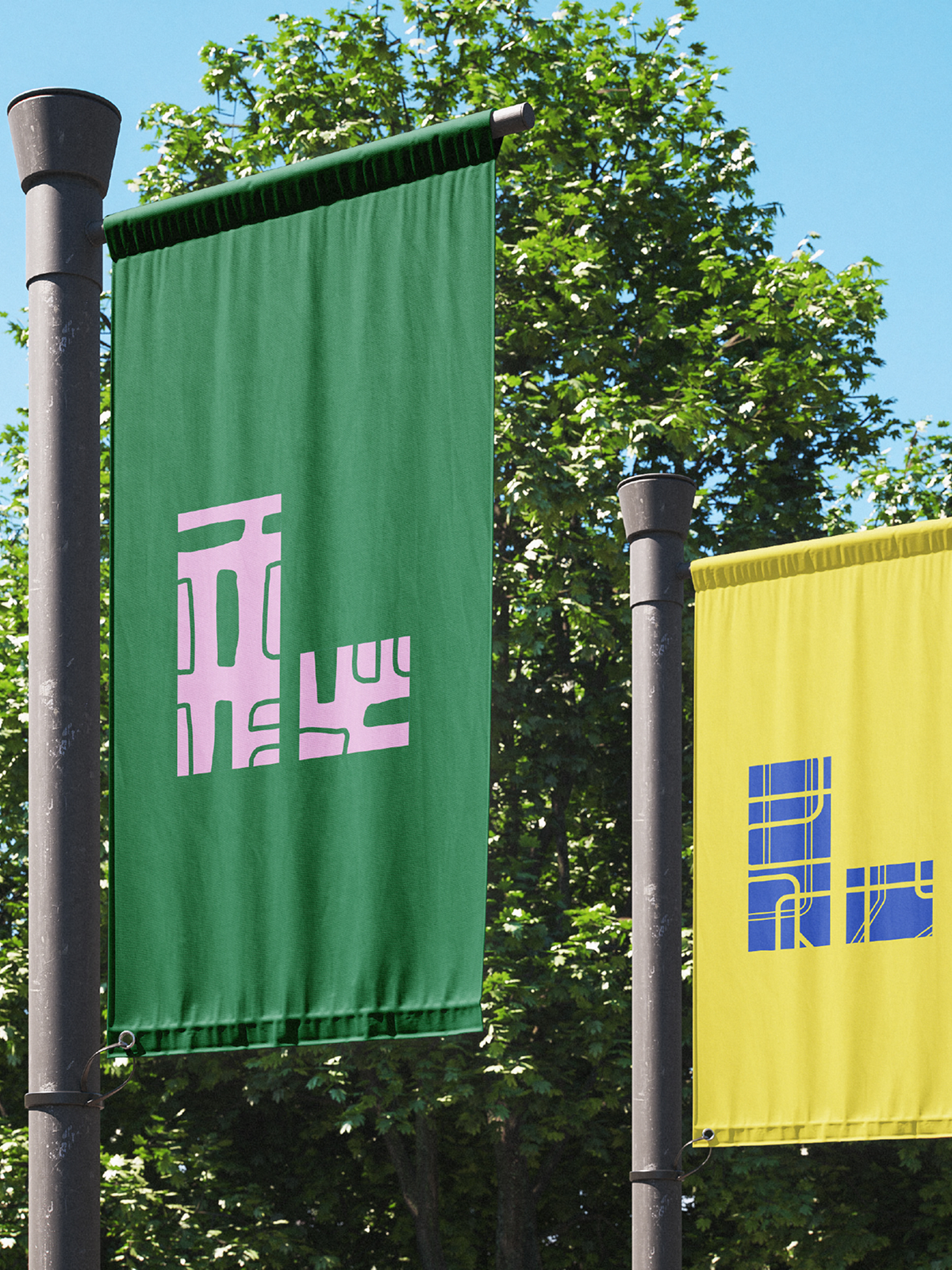 Green and yellow City of London Wayfinding banners on flagposts with trees in background