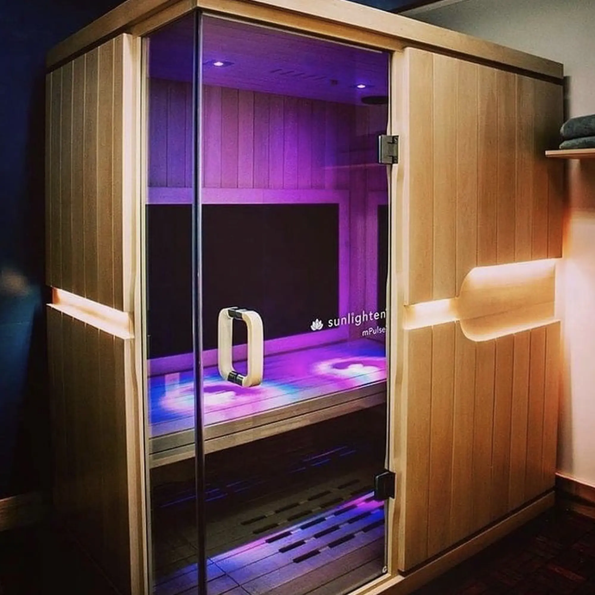 A calming sauna space with a transparent glass door and gentle lighting, perfect for a soothing experience.