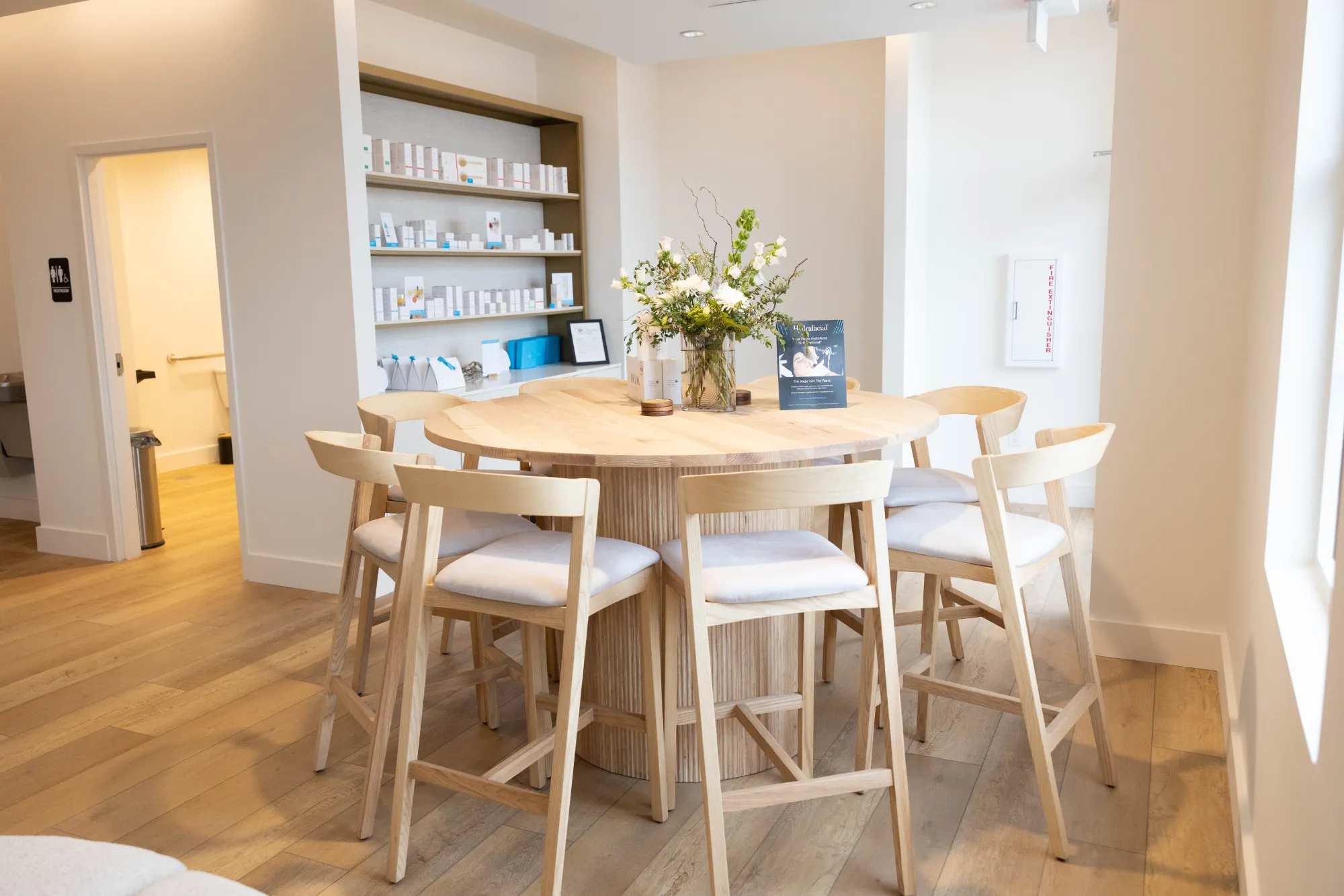 A table surrounded by chairs, adorned with a vase of colorful flowers at its center, creating an inviting atmosphere.