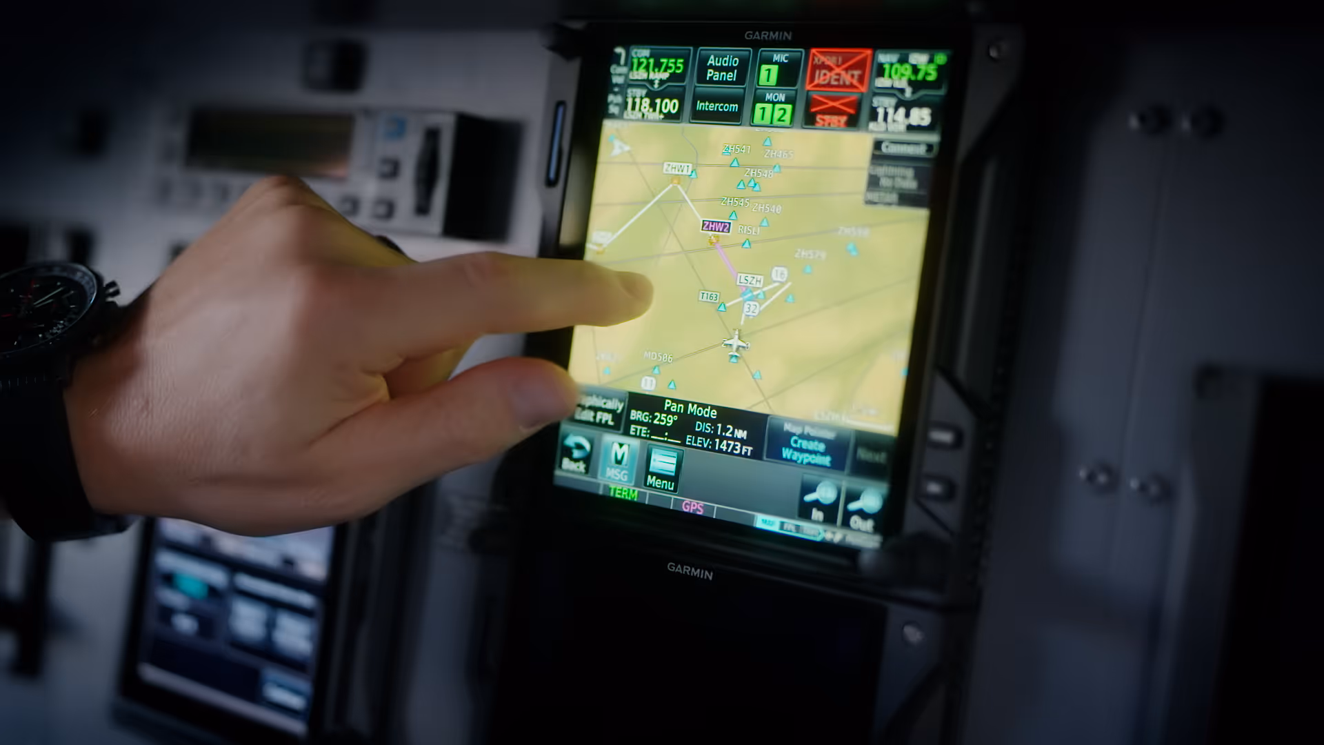 Hand selecting route on Garmin aviation navigation touchscreen display.