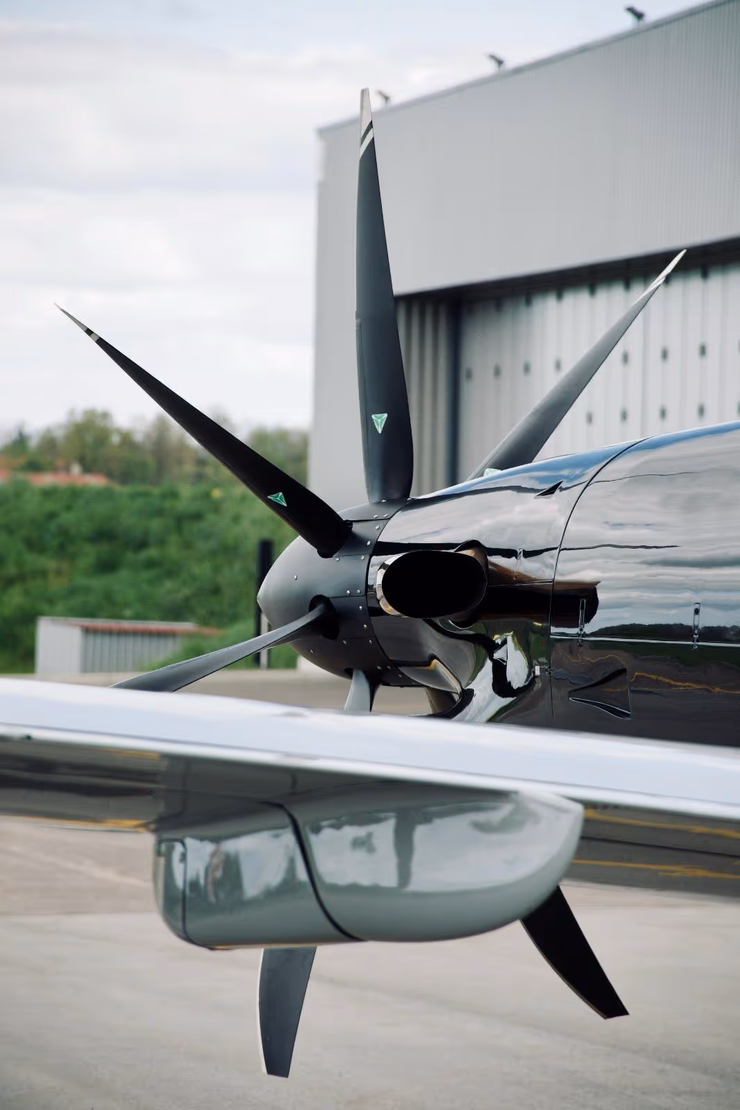 Close-up of Pilatus aircraft propeller and engine nacelle near hangar.