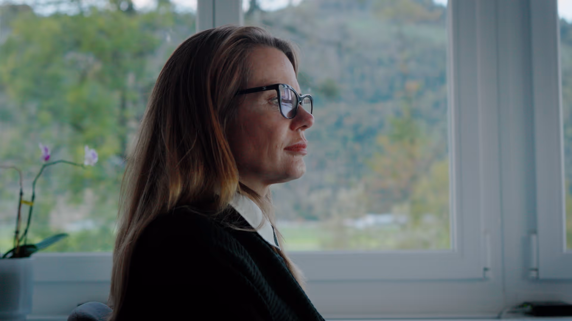 Businesswoman with glasses working at her computer thoughtfully.