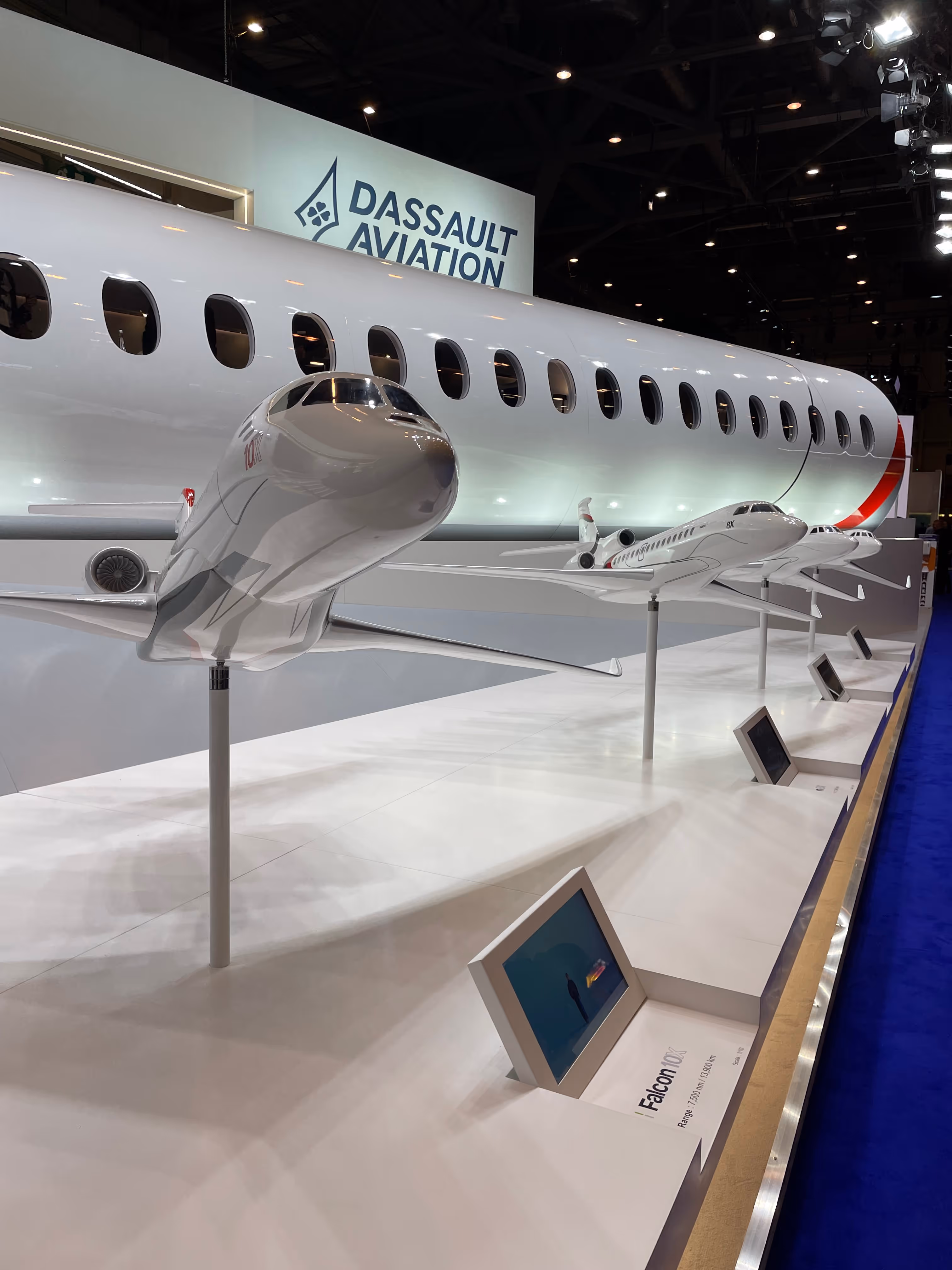 Dassault Aviation stand with Falcon jet models on display at an aerospace exhibition.