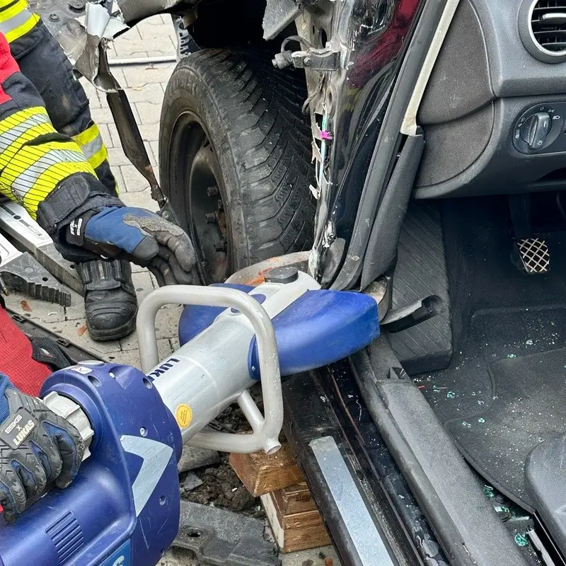Feuerwehrmann benutzt hydraulisches Rettungsgerät, um eine beschädigte Fahrzeugtür bei einem Unfall zu öffnen. Unfallrettung Training Technical Rescue Rheinhessen