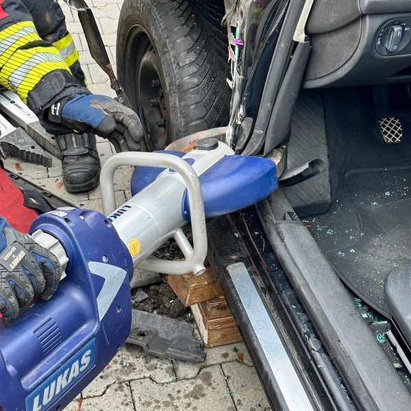Feuerwehrmann benutzt hydraulisches Rettungsgerät, um eine Autotür für eine Unfallrettung zu öffnen. PKW Unfallrettung Seminar