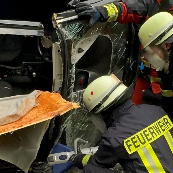 Feuerwehrmänner im Einsatz beim Aufschneiden zerbrochener Fahrzeugscheiben zur Unfallrettung. PKW Unfallrettung Seminar