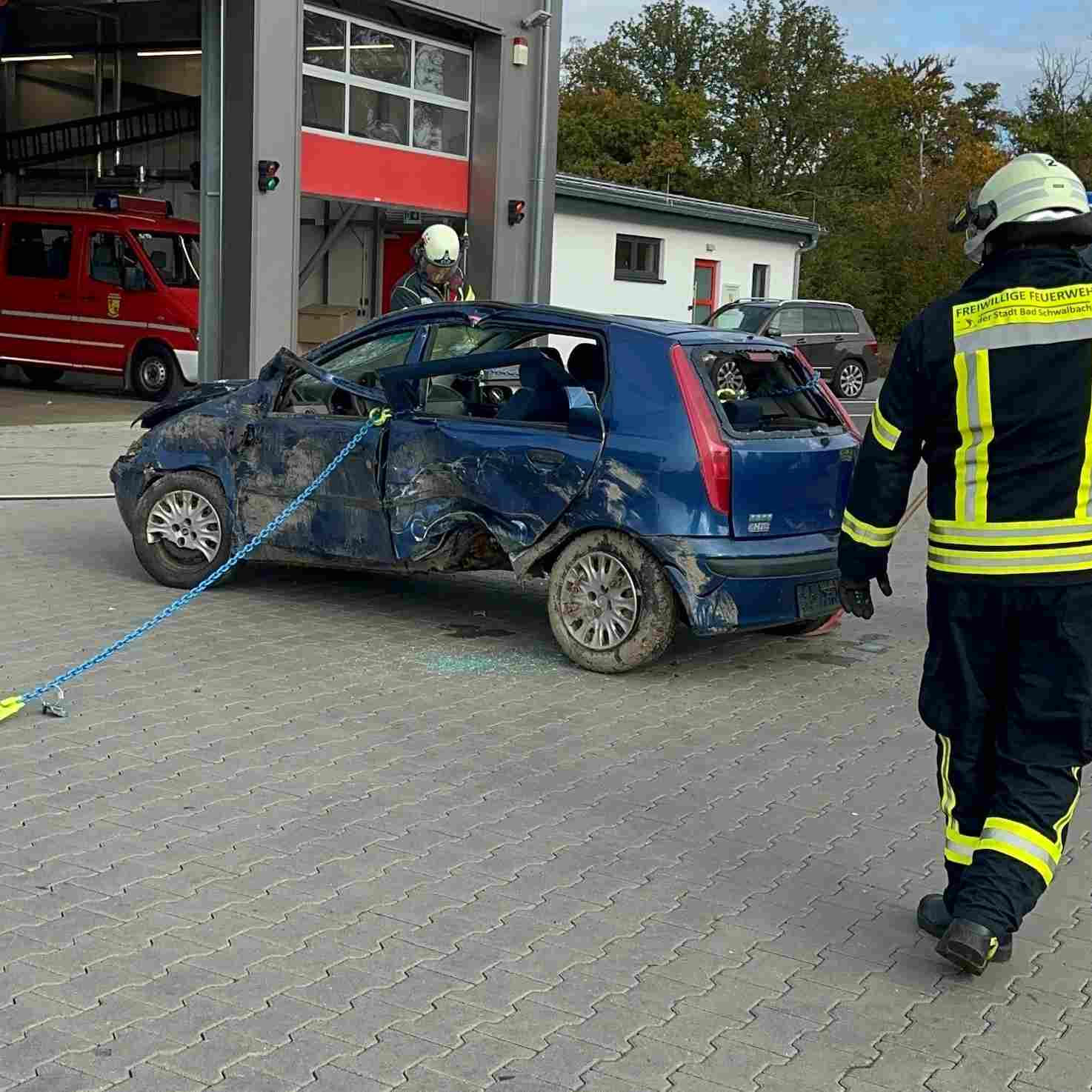 Beschädigtes blaues Auto wird von Feuerwehrleuten der Freiwilligen Feuerwehr Bad Schwalbach mit einer Kette gesichert. Seminar Kettenrettung nach der Oslomethode - Training Technical Resuce RH
