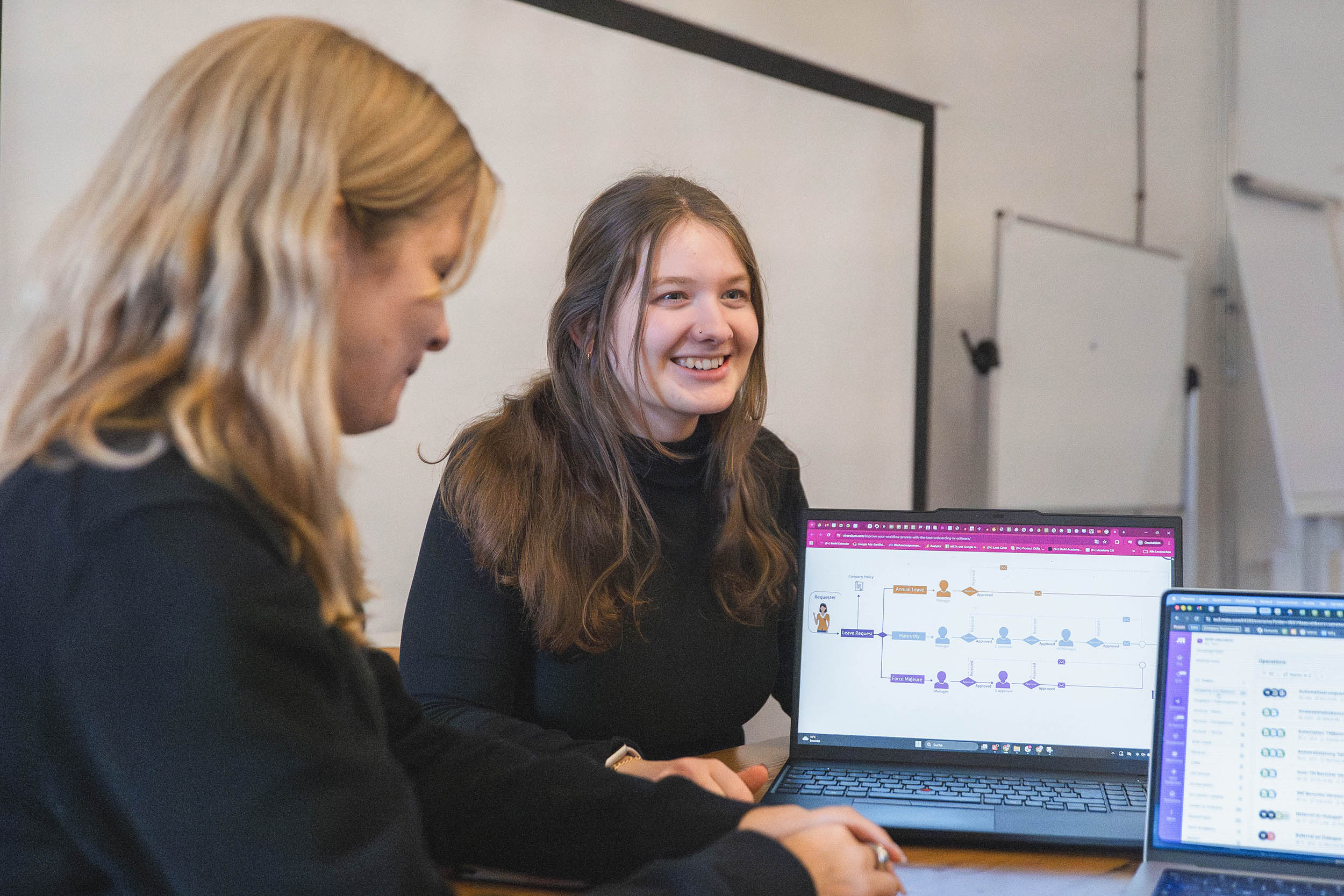 Eine weibliche Person spricht mit ihren Kolleg:innen über KI und Automation im HR