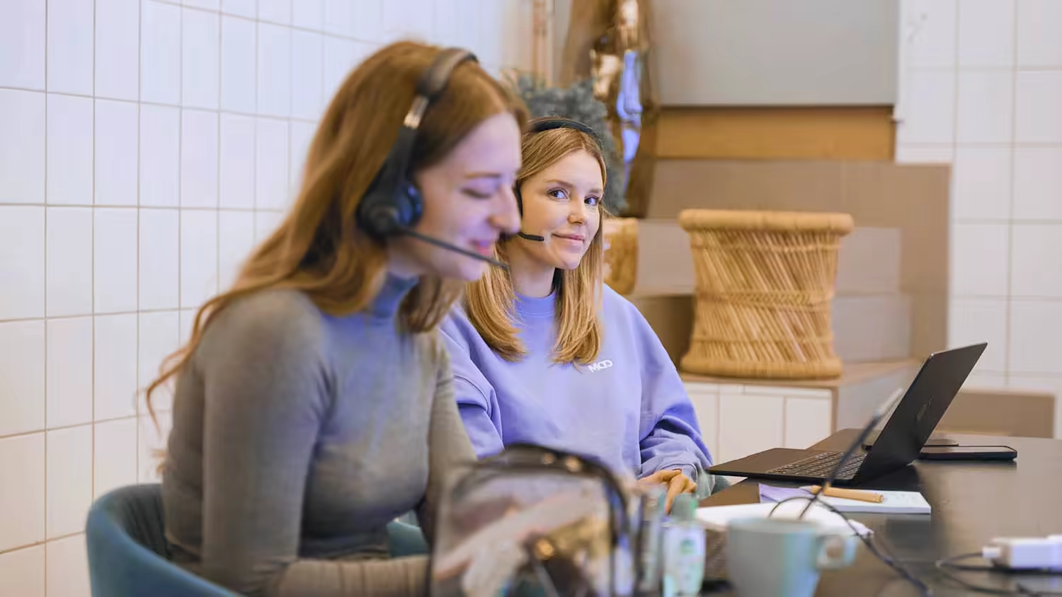 Zwei Teilnehmerinnen mit Headsets am Laptop während einer Verkaufsübung in der MOD Weiterbildung Digital Sales.