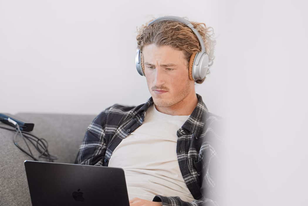 Eine Person mit Kopfhörern am Laptop – Symbolfoto zur Online-Marketing-Weiterbildung im Homeoffice.