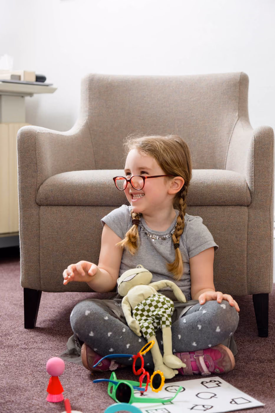Little Girl Wearing Glasses and Sitting on The Floor