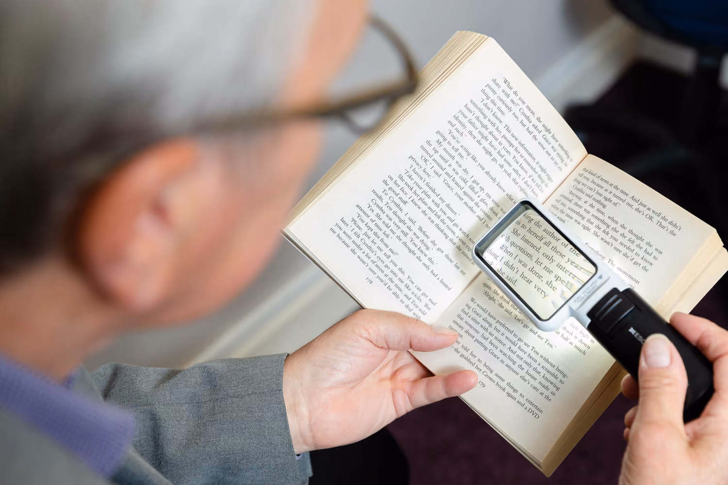 Man using magnifying glass to read