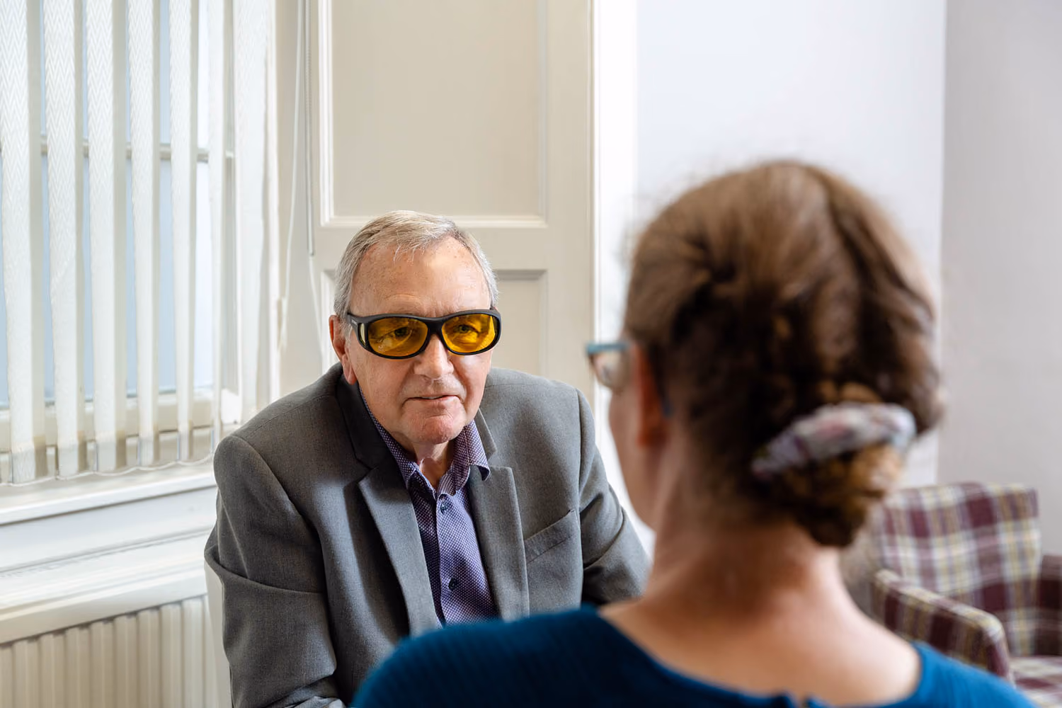 optom doing sight test of old man