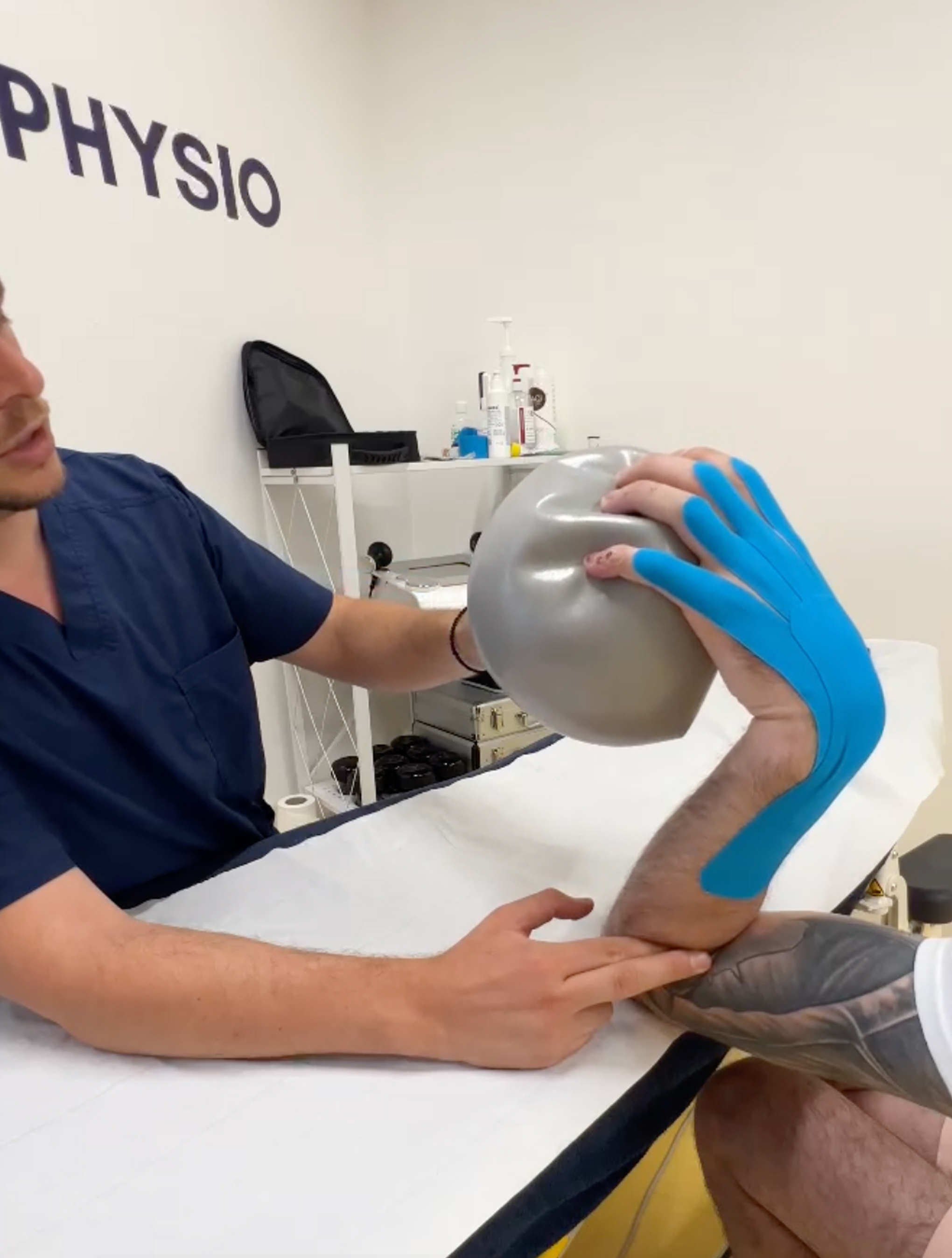 Image of a person in medical clothes checks the elbow of another person