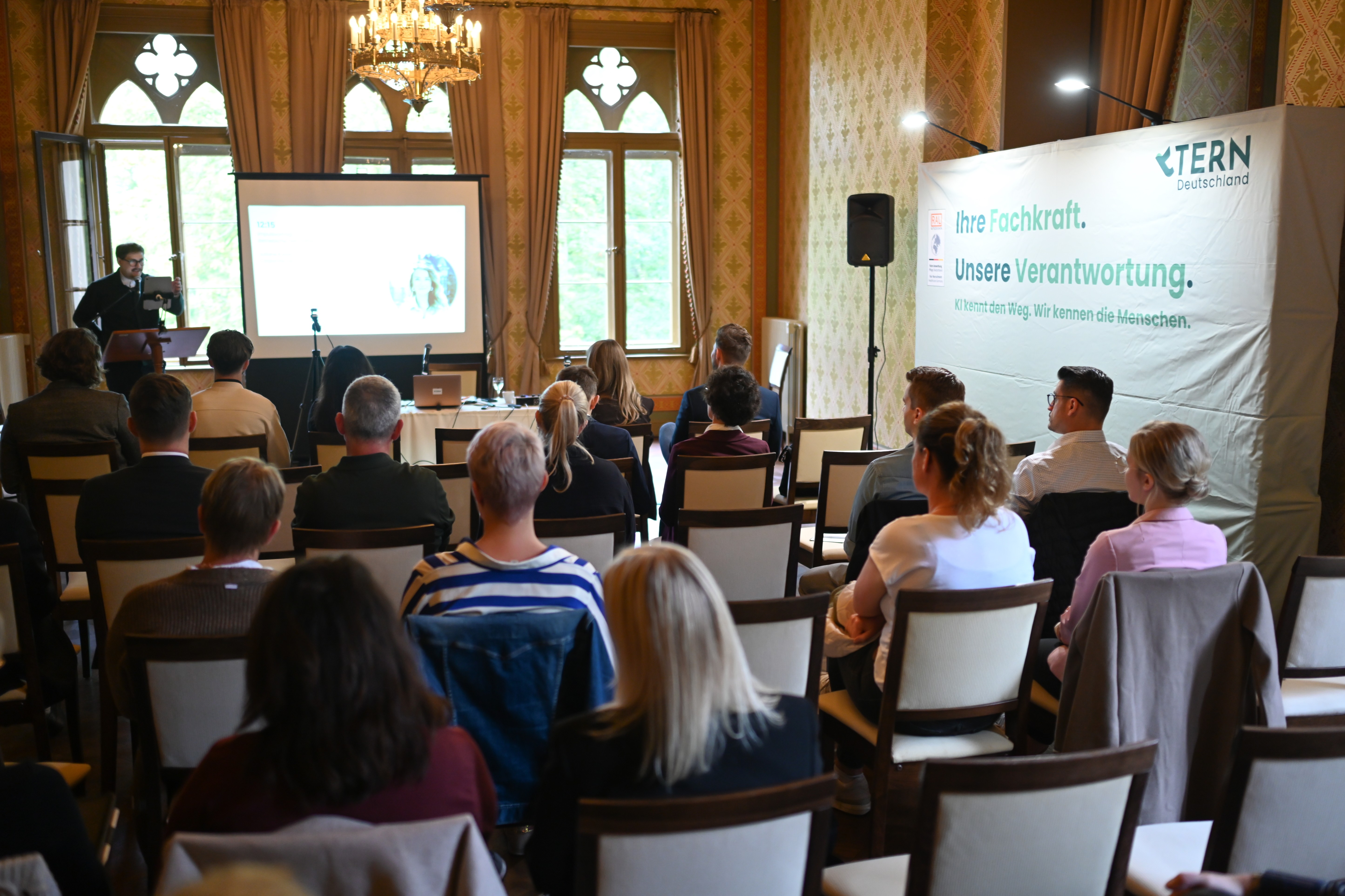 Back view of an audience listening to a presentation
