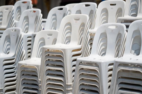 Gestapelte weiße Plastikstühle im Freien