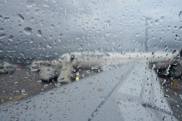 Raindrops on airplane window at airport