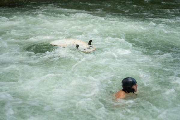 Surfer navigating Eisbachwelle rapids