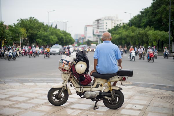 Mann auf Motorrad an belebter Kreuzung in Hanoi